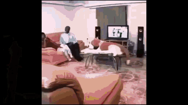 a blurry picture of a living room with a man sitting on a couch and a tv