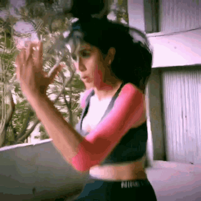 a woman in a nike crop top and shorts is dancing