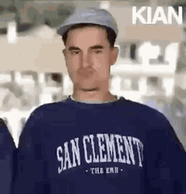 a man wearing a blue hat and a blue sweatshirt is making a funny face .