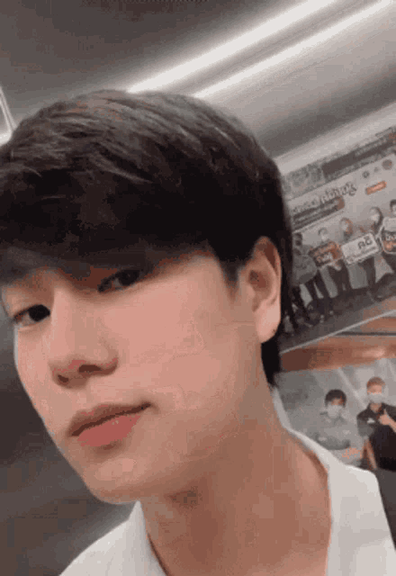 a close up of a young man 's face with a sign in the background that says ' nc '