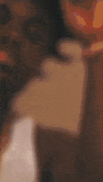 a close up of a person 's face with a blurred background and a statue in the background .