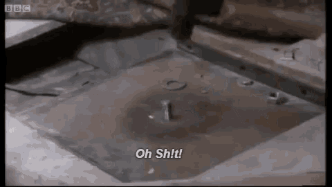 a person is hammering a screw into a hole in a metal surface .