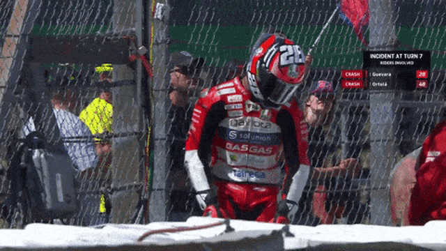 a motorcycle racer wearing a red and white outfit with the number 26 on it