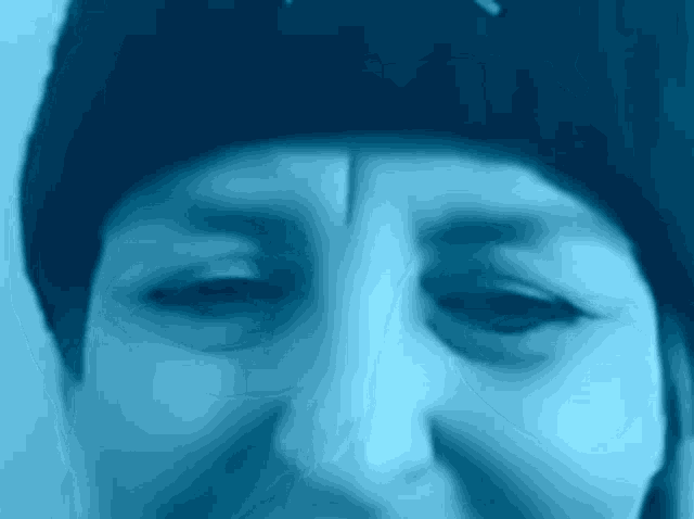 a close up of a person 's face with a blue background .