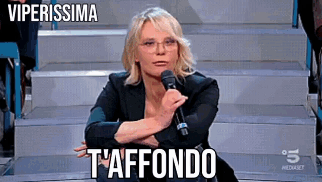 a woman sitting on stairs with a microphone and the words viperissima t'afondo above her