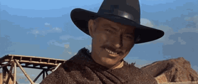 a man with a mustache is wearing a black hat