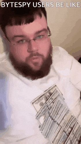 a man with a beard and glasses is holding a pile of money and says " bytespy users be like " on the bottom