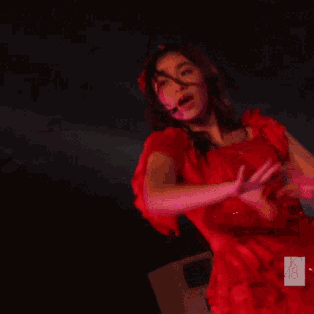 a woman in a red dress has the number 48 on her sleeve