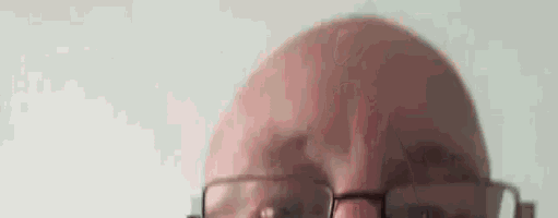 a close up of a man 's head with glasses .