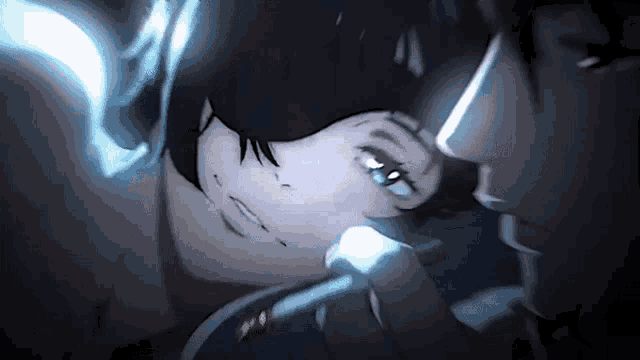 a man and a woman are kissing in a dark room with a light shining on them .