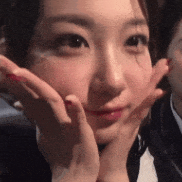 a close up of a woman making a face with her hands on her face .