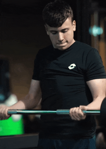 a man wearing a black shirt with a lotto logo on it holds a barbell