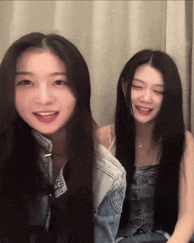 two girls with long hair are smiling and looking at the camera