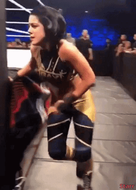 a female wrestler is kneeling down in a wrestling ring with the word starr on the bottom