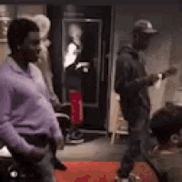 a man in a purple shirt is standing in a room with other people