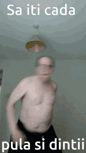 a man without a shirt is dancing with the words sa iti cada pula si dintii behind him
