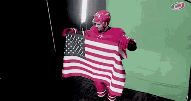 a hockey player is holding an american flag in front of a green screen ..