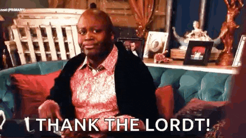 a man is sitting on a couch in a living room and saying `` thank the lord '' .