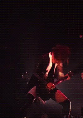 a woman is playing a guitar on a stage with the name eshika on the bottom left