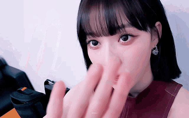a close up of a woman covering her face with her hands