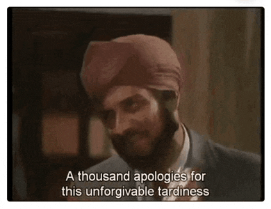 a man in a suit and tie is wearing a turban and talking .