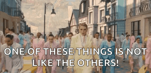 a woman is walking down a street with a crowd of people in suits .