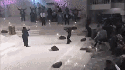 a group of people are dancing on a stage in front of a crowd of people .