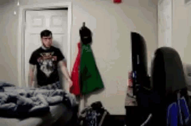 a man in a black shirt is standing next to a woman in a room .