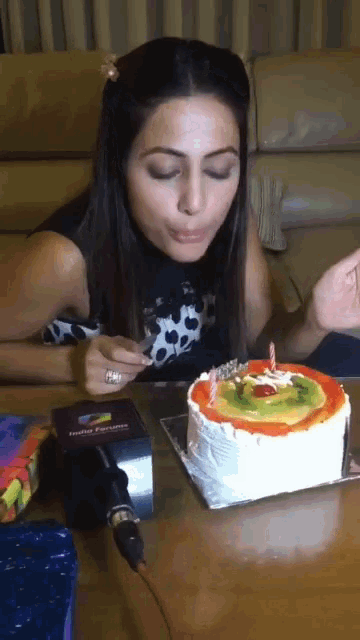 a woman is blowing out a candle on a cake