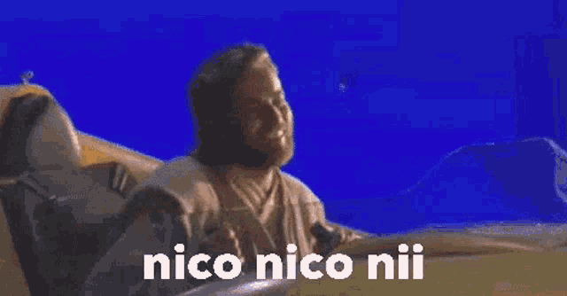 a man sitting in a boat with the words nico nico niu written on the screen