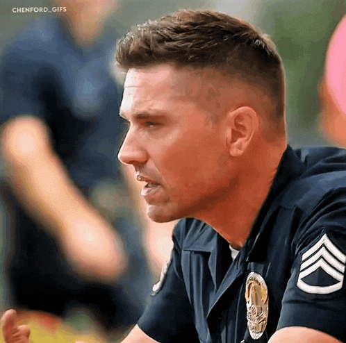 a close up of a police officer with a chevron on his sleeve