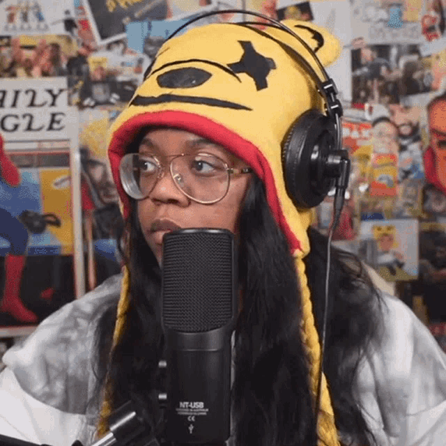 a woman wearing a winnie the pooh hat and headphones is speaking into a microphone