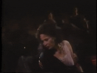 a man is holding a woman in a dark room .