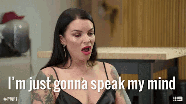 a woman is sitting at a table and says i 'm just gonna speak my mind