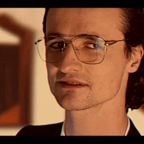 a close up of a man wearing glasses and a black suit