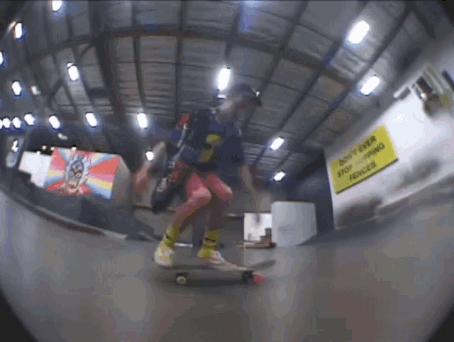 a person riding a skateboard in front of a sign that says do n't enter