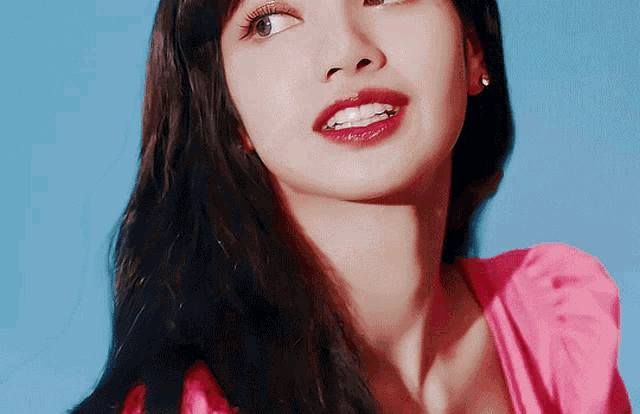 a close up of a woman 's face with a pink top on