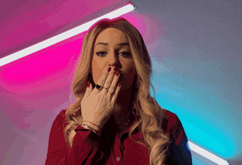 a woman with red nails and a ring on her finger covers her mouth