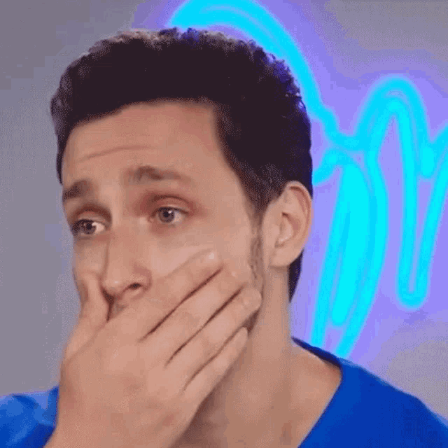 a man with a surprised look on his face covering his mouth