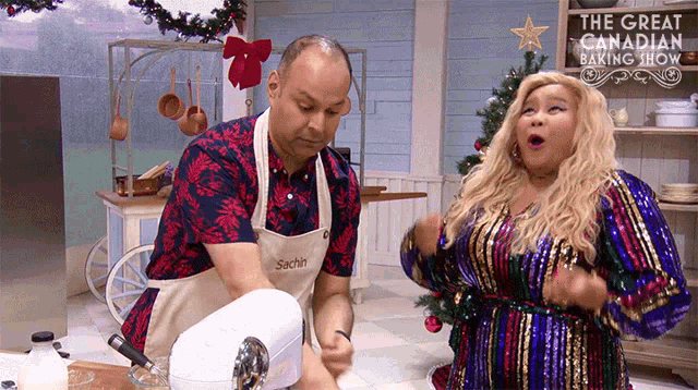 a man and a woman are dancing in front of a sign that says " the great canadian baking show "