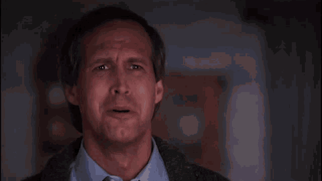 a man in a blue shirt and tie making a funny face