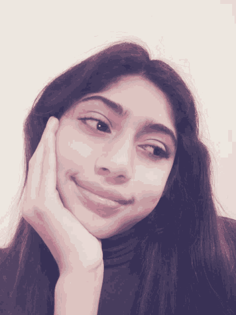 a girl with a hand on her chin looks at the camera