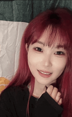 a girl with red hair and black eyes is smiling