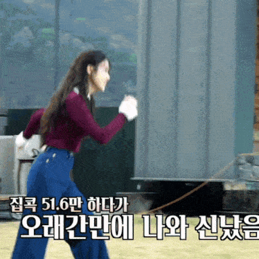 a woman in a burgundy top and blue pants is running with a rope