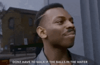 a man is standing in front of a building and talking about balls in the water .