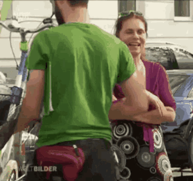 a man wearing a green shirt is talking to a woman