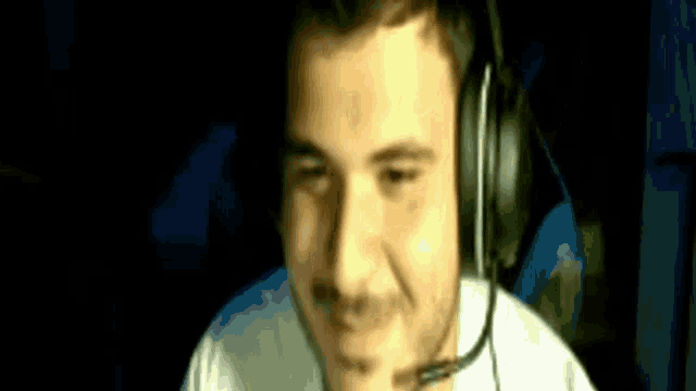 a man wearing headphones and a microphone smiles