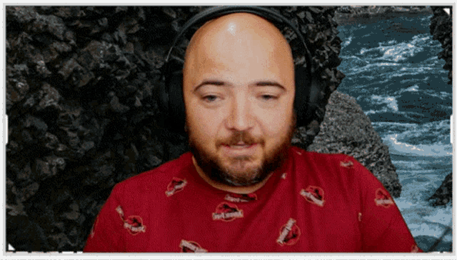 a bald man wearing headphones and a red shirt that says jurassic world