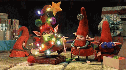 a group of elves are decorating a christmas tree with a star on top