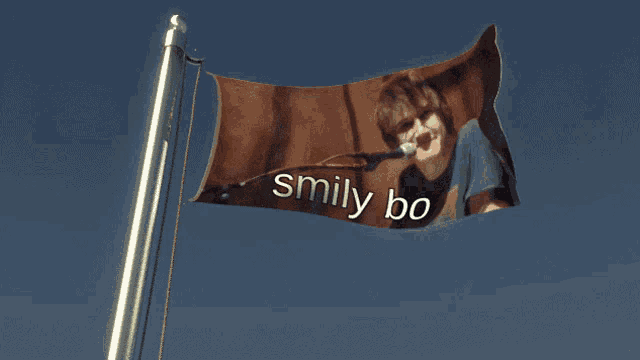 a flag with smily bo written on it is flying in the wind